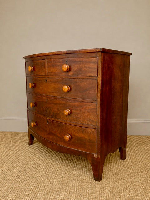 Antique bow front chest of drawers showing curved mahogany front 