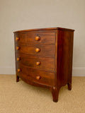 Antique bow front chest of drawers showing curved mahogany front 