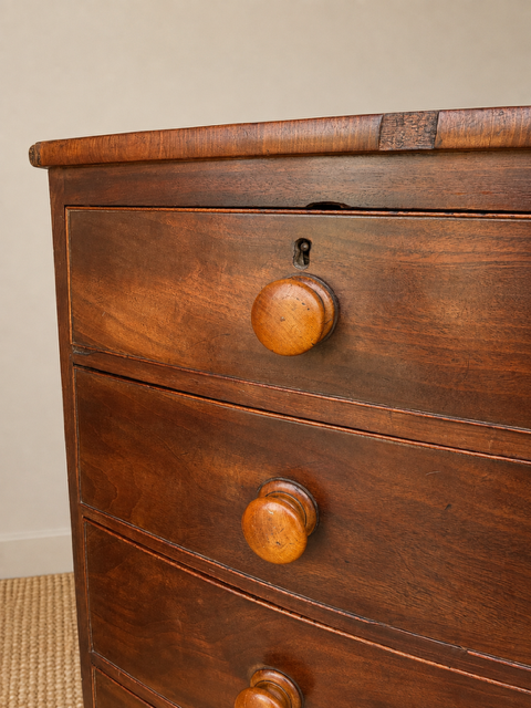 Antique mahogany chest of drawers showing age related veneer loss 