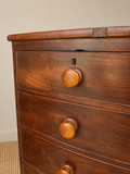 Antique mahogany chest of drawers showing age related veneer loss 