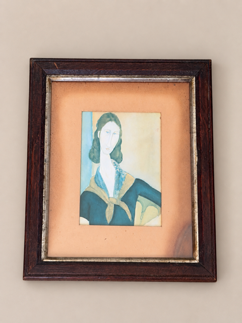 Vintage print of Modigliani depicting Jeanne in a blue dress and ochre scarf, displayed in a dark wooden frame with metallic inner boarder and aged ochre mount 