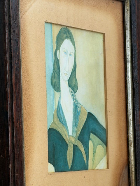 Angled ochre mount, metallic inner trim close up of a vintage Modigliani portrait print of Jeanne, showing the ochre mount, metallic inner trim and dark wooden frame 